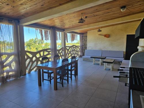 a dining room with a table and chairs and windows at LE KABOSS in Toliara