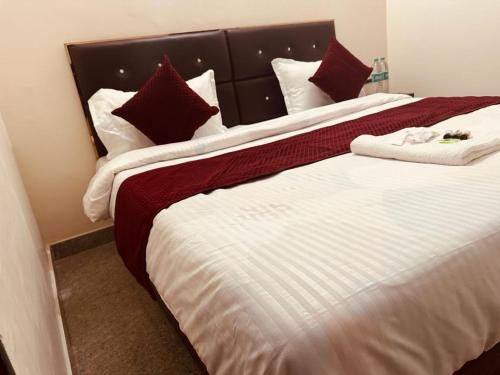 a bedroom with two beds with red and white sheets at The Lord Krishna Residency Vrindavan in Vrindāvan