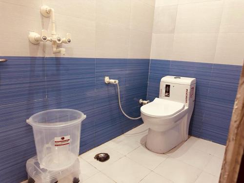 a bathroom with a toilet and a trash can at The Lord Krishna Residency Vrindavan in Vrindāvan