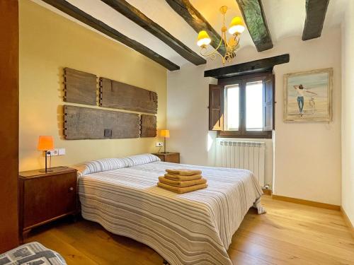1 dormitorio con 1 cama grande y toallas. en Casa Larriz, en Artázcoz