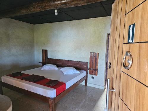 a bedroom with a bed and a wooden door at LE KABOSS in Toliara