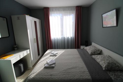 a bedroom with a bed with a dresser and a window at Къща за гости Света Марина in Krapets