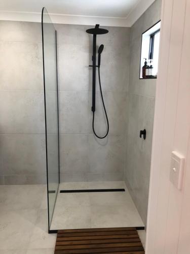 a shower with a glass shower stall in a bathroom at The White Room in Yeppoon