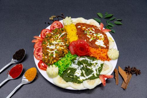 un plato de comida con diferentes tipos de comida en Hotel Darshan Executive, en Tuljapur