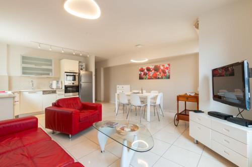 een woonkamer met een rode bank en een tafel bij Hilton Beach 2BR in Tel Aviv