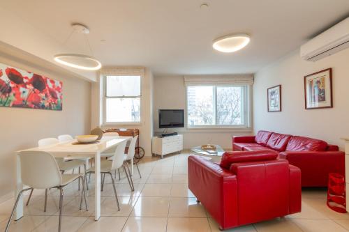 a living room with a red couch and a table at Hilton Beach 2BR in Tel Aviv