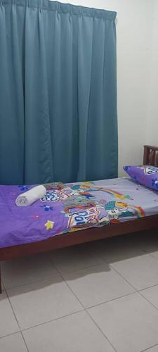 Bett in einem Zimmer mit einem blauen Vorhang in der Unterkunft Anggun Boutique Homestay in Kampong Jalan Bahru