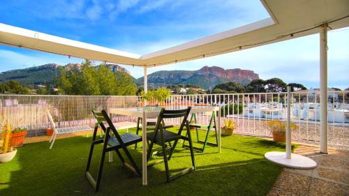 a table and chairs under an umbrella on a patio at SUNSET GARDEN - Roof Top 45 m2 Vue Mer / Cap Canaille in Cassis