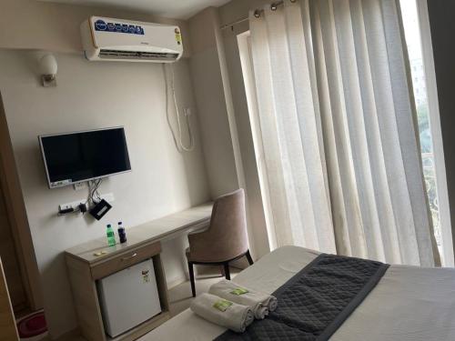 溫達文的住宿－Vrindavan Rooms，一间卧室配有一张床、一张书桌和一台电视