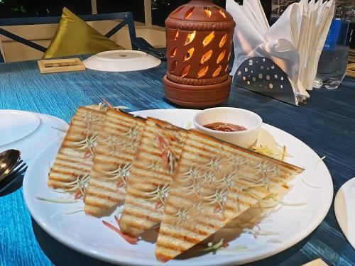 a white plate with two slices of food on a table at Soham Haveli Udaipur in Udaipur