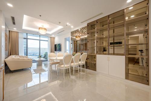 a kitchen with white cabinets and a dining room at Landmark 81 SHA PLUS Residence in Ho Chi Minh City