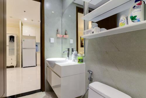 a white bathroom with a sink and a refrigerator at Landmark 81 SHA PLUS Residence in Ho Chi Minh City