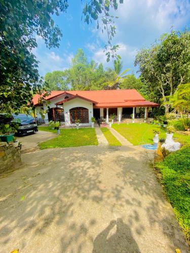 une maison avec un toit rouge et une allée dans l'établissement Green willa, à Badulla