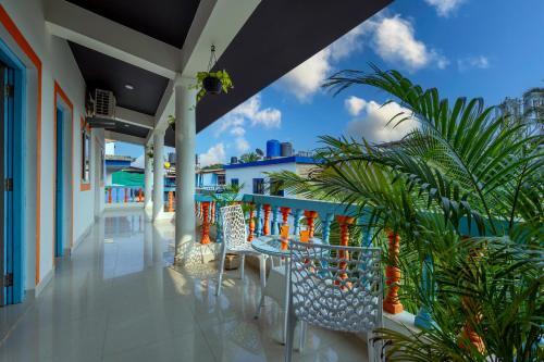 uma varanda de um resort com uma mesa e cadeiras em Beach Doorz Place-TBV em Baga