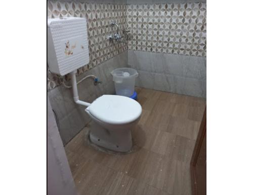 La salle de bains est pourvue de toilettes blanches. dans l'établissement White House Resort, Sansari kund, Guptkashi, à Ukhimath