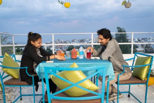 a man and a woman sitting at a blue table at Soham Haveli Udaipur in Udaipur
