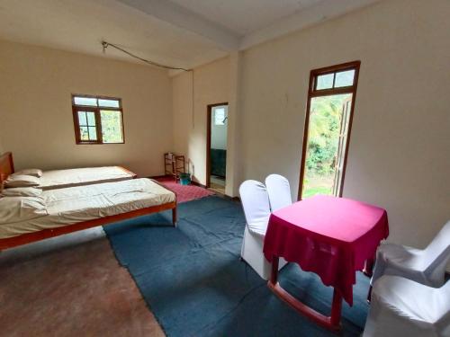 - une chambre avec un lit, une table et des chaises dans l'établissement NSM Wedding hall and guest house, à Badulla