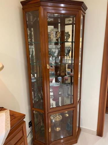 a wooden cabinet with glass doors in a room at Seaview Family Apartment, Pool, Easy Access to the Sea, Near Mellieħa Bay in Mellieħa