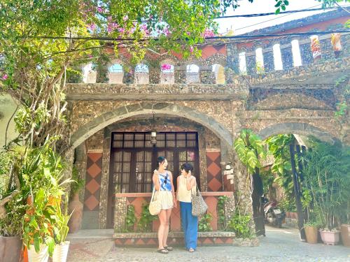 two women standing in front of a building at Sầm Sơn Boutique Hotel Phan Thiết in Phan Thiet