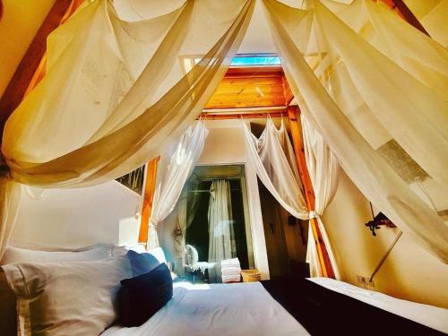 ein Schlafzimmer mit einem großen Bett mit Vorhängen in der Unterkunft Nomado Boutique Hotel in Ulaanbaatar