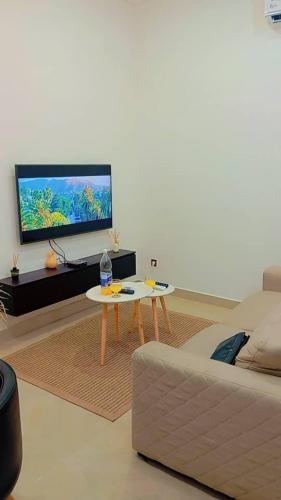 a living room with a couch and a table and a tv at Appart boa in Cotonou