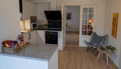 una pequeña cocina con una barra y una silla. en Hyggelig byhus i stueplan med solrig gårdhave, en Svendborg