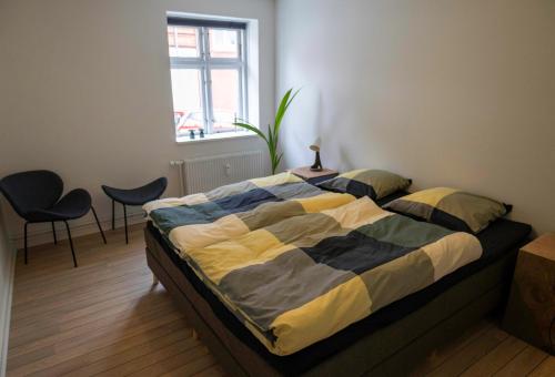En eller flere senge i et værelse på Hyggelig byhus i stueplan med solrig gårdhave