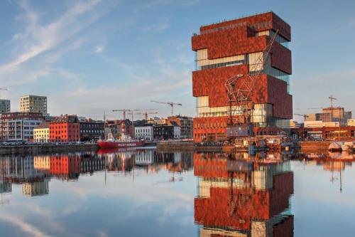 a building sitting next to a body of water at Charming Bohemian central app in Antwerp