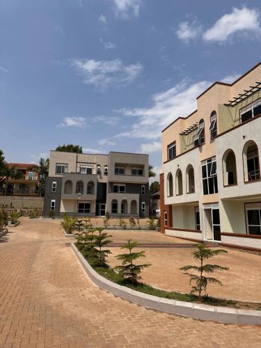 a group of buildings with trees in a courtyard at Vera's Luxury Home Near Speke Resort Munyonyo in Munyonyo