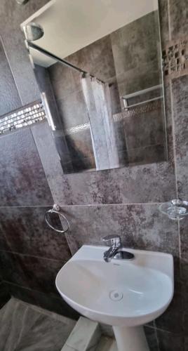 a bathroom with a sink and a mirror at Santa Clara Apt in Ciudad Juárez