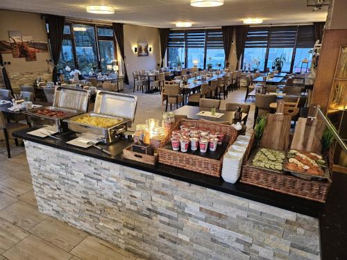 a restaurant with a counter with food on it at Aktiv Hotel Winterberg in Winterberg