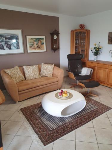 una sala de estar con un sofá y una mesa en Ferienwohnung Sonnenschein mit Pool und Sauna, en Lahnstein