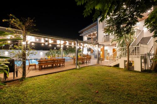 a deck with a table and benches and lights at Tirta Spring Villa with Hotspring Pool in Los Baños