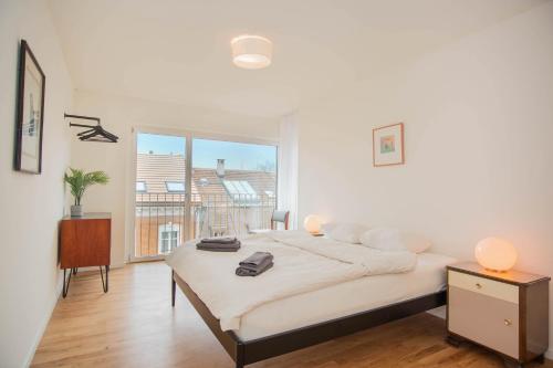 巴塞爾的住宿－Modern Apartment in the heart of Basel，白色的卧室设有床和大窗户
