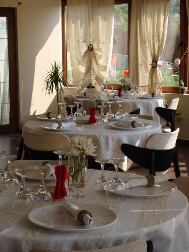 a group of tables with white tablecloths and wine glasses at Pensiunea Taverna Bucium in Iaşi