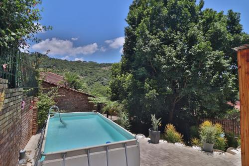 a swimming pool in a yard with trees and a fence at Sleep Haven Self-Catering Accommodation - Nelspruit in Nelspruit