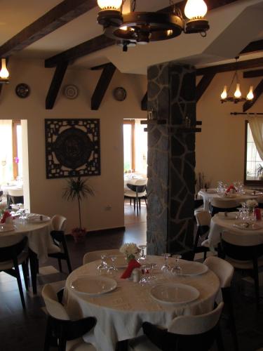 a dining room with white tables and chairs at Pensiunea Taverna Bucium in Iaşi
