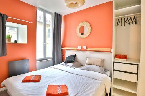 a bedroom with an orange wall and a bed at SAULSTICE, Appartement cosmique hyper centre in Auxerre