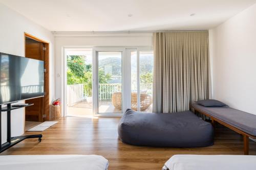 a room with a bed and a flat screen tv at Tirta Spring Villa with Hotspring Pool in Los Baños