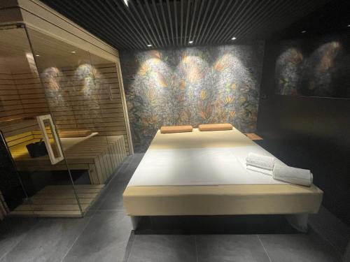 a bed in a room with a painting on the wall at Apartments Prekmurska vas - Vital Resort in Moravske Toplice