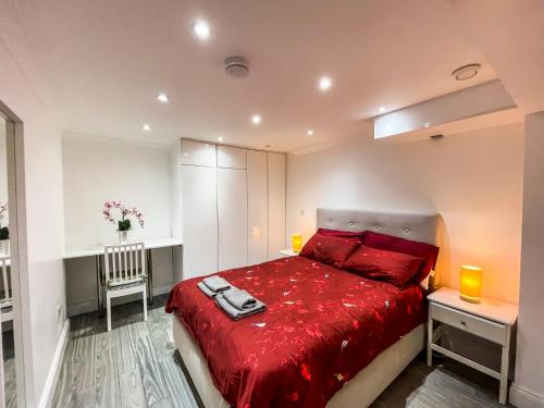 a bedroom with a red bed with two lamps at 1 Bedroom Flat with whirlpool bath in London