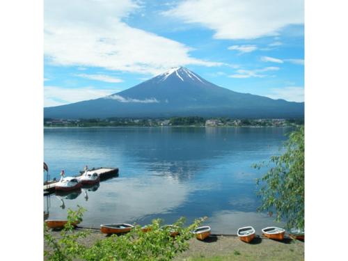 a mountain on a lake with boats in the water at Lake Kawaguchi Rental Villa Tozawa Center - Vacation STAY 46680v in Oishi