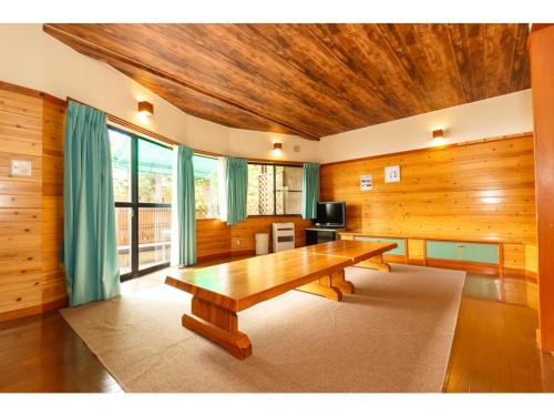 大石的住宿－Lake Kawaguchi Rental Villa Tozawa Center - Vacation STAY 46845v，一间带木桌和电视的用餐室