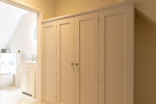 a closet with white cabinets in a room at Plas Robin in Llandyssil