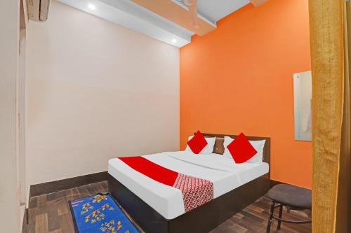a bedroom with a bed with an orange wall at Super Hotel O New Pacifica Grand in Alambagh