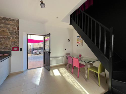 uma sala de jantar com uma mesa e cadeiras e uma escadaria em Love Room du Moulin Rose em Trans-en-Provence