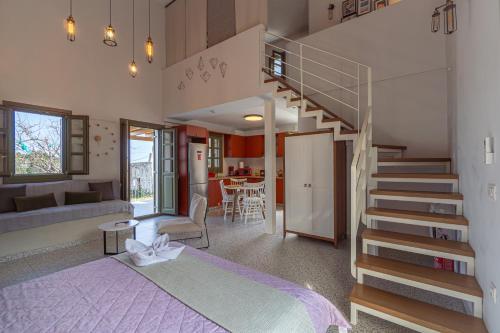 - une chambre avec un lit et un escalier en colimaçon dans l'établissement Villa Rosa - Luxury Villas with Panoramic Views, à Lagoúdi Zía