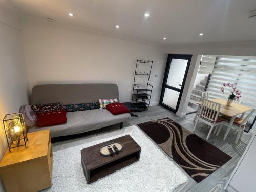 uma sala de estar com uma cama e uma mesa em 1 Bedroom Flat with whirlpool bath em Londres