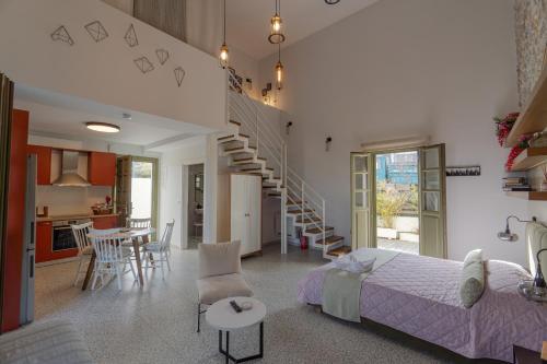 a bedroom and living room with a bed and a staircase at Villa Rosa - Luxury Villas with Panoramic Views in Lagoúdi Zía