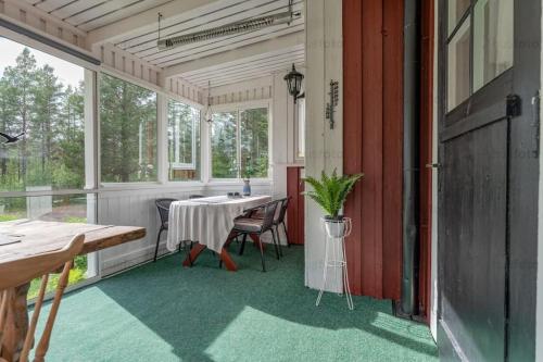 a screened in porch with a table and chairs at Nära fjäll och natur! in Vemhån